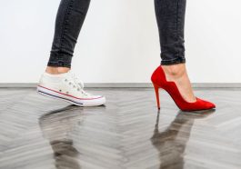 スニーカーと赤いヒールの女性の足