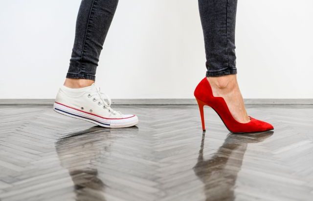 スニーカーと赤いヒールの女性の足
